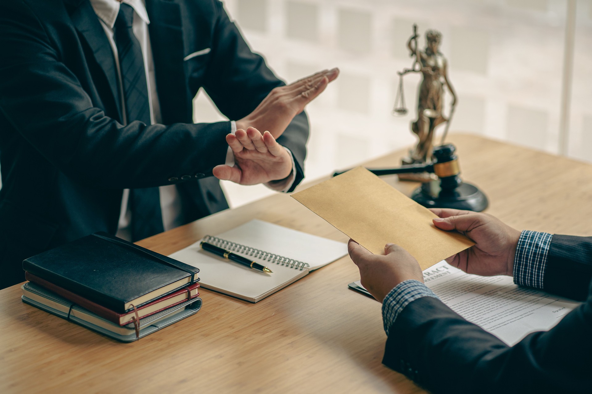 The lawyer was offered money, but he refused the client's offer on a table with a hammer and golden scales.